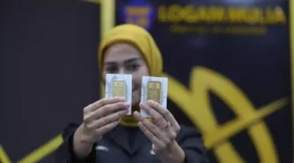 Pegawai menunjukkan emas Antam (ANTM) di butik emas LM Antam. (Investor Daily/David Gita Roza)