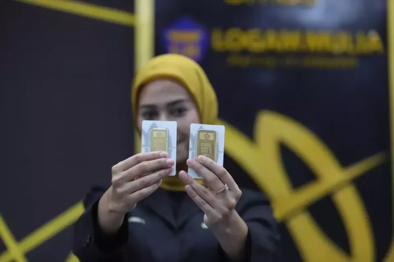 Pegawai menunjukkan emas Antam (ANTM) di butik emas LM Antam. (Investor Daily/David Gita Roza)