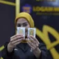 Pegawai menunjukkan emas Antam (ANTM) di butik emas LM Antam. (Investor Daily/David Gita Roza)