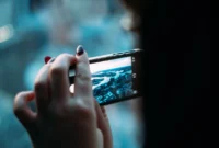 close-up tangan memegang smartphone transparan bodi kaca futuristik (Foto: Get)