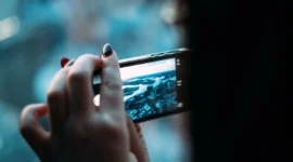 close-up tangan memegang smartphone transparan bodi kaca futuristik (Foto: Get)