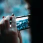 close-up tangan memegang smartphone transparan bodi kaca futuristik (Foto: Get)