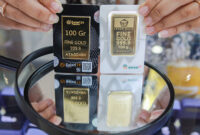 Karyawan menunjukkan emas Galeri 24 Pegadaian dan Antam di Galeri 24, Jakarta, Selasa (21/5/2024). (Bloomberg Technoz/Andrean Kristianto)