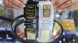 Karyawan menunjukkan emas Galeri 24 Pegadaian dan Antam di Galeri 24, Jakarta, Selasa (21/5/2024). (Bloomberg Technoz/Andrean Kristianto)